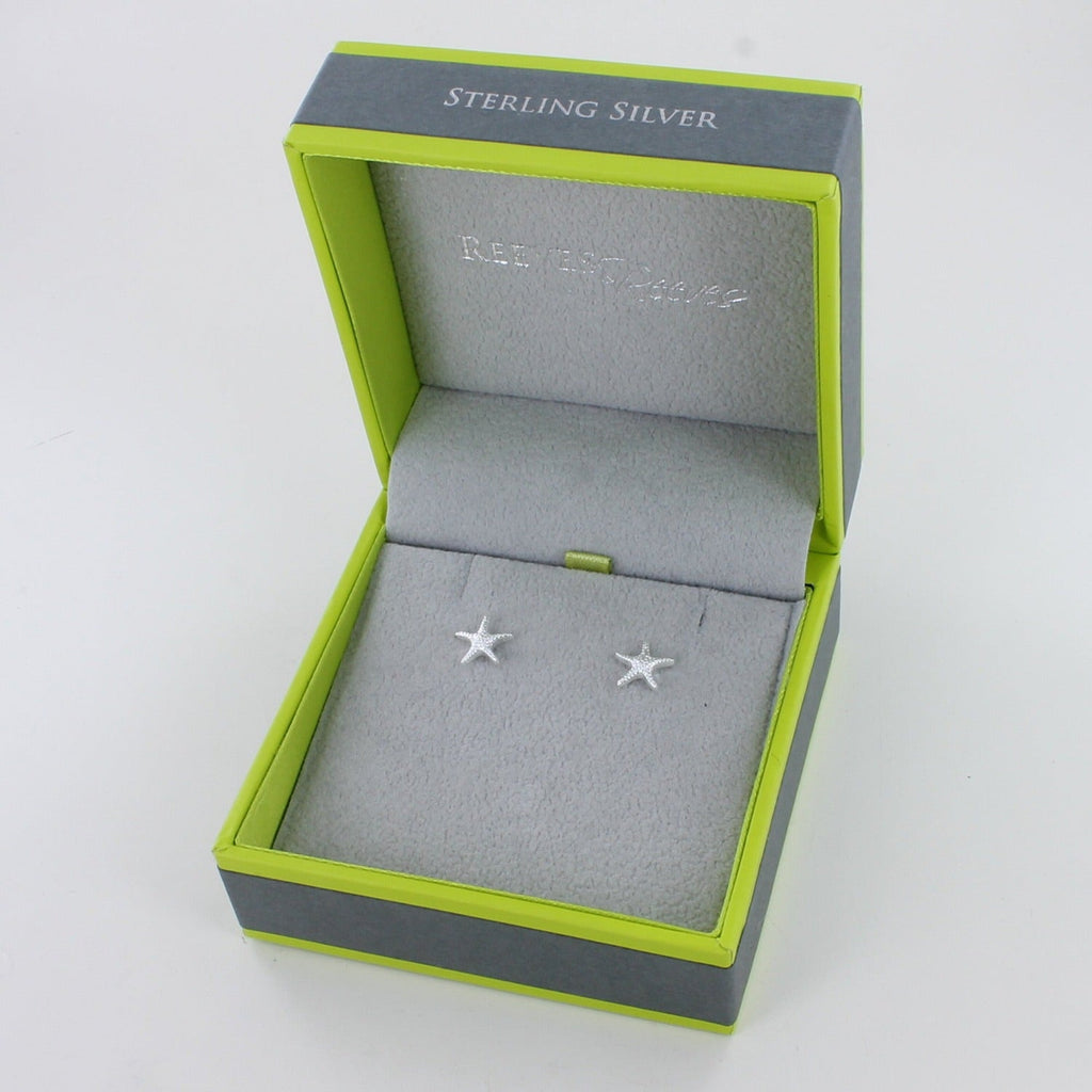 A sterling silver starfish stud earring, shown in a Reeves & Reeves grey and green gift box.