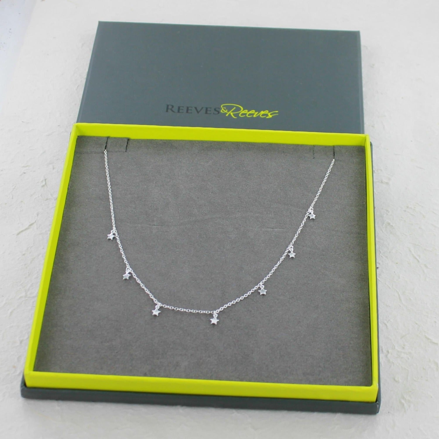 Sterling Silver Star Necklace in a Reeves & Reeves branded gift box with grey and green colours.