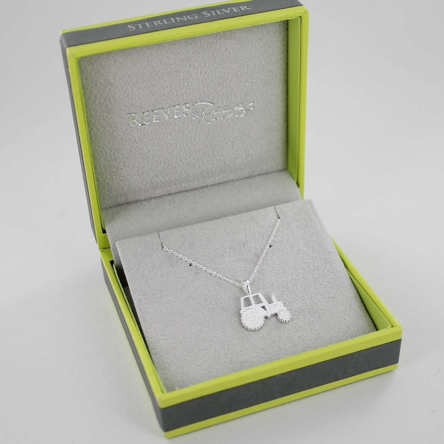 A sterling silver tractor necklace, on an adjustable silver chain and shown in a Reeves & Reeves gift box.
