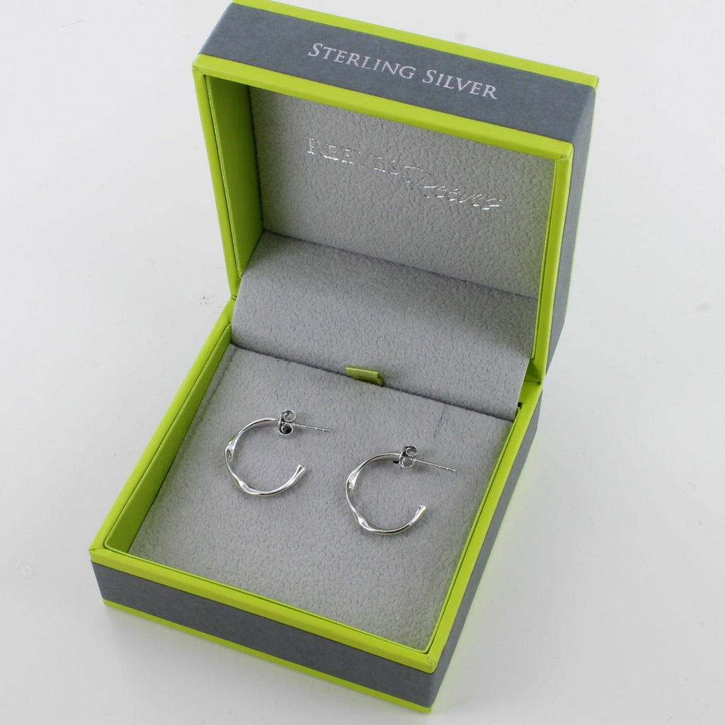 A pair of sterling silver hoops, with a twisted design and shown in a Reeves & Reeves grey and green gift box.