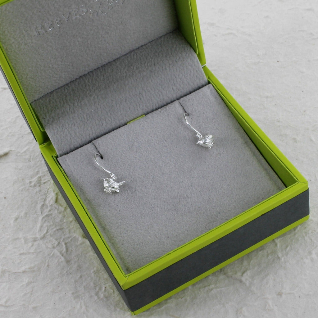 A pair of sterling silver Wren Drop Earrings, shown in a Reeves & Reeves gift box.