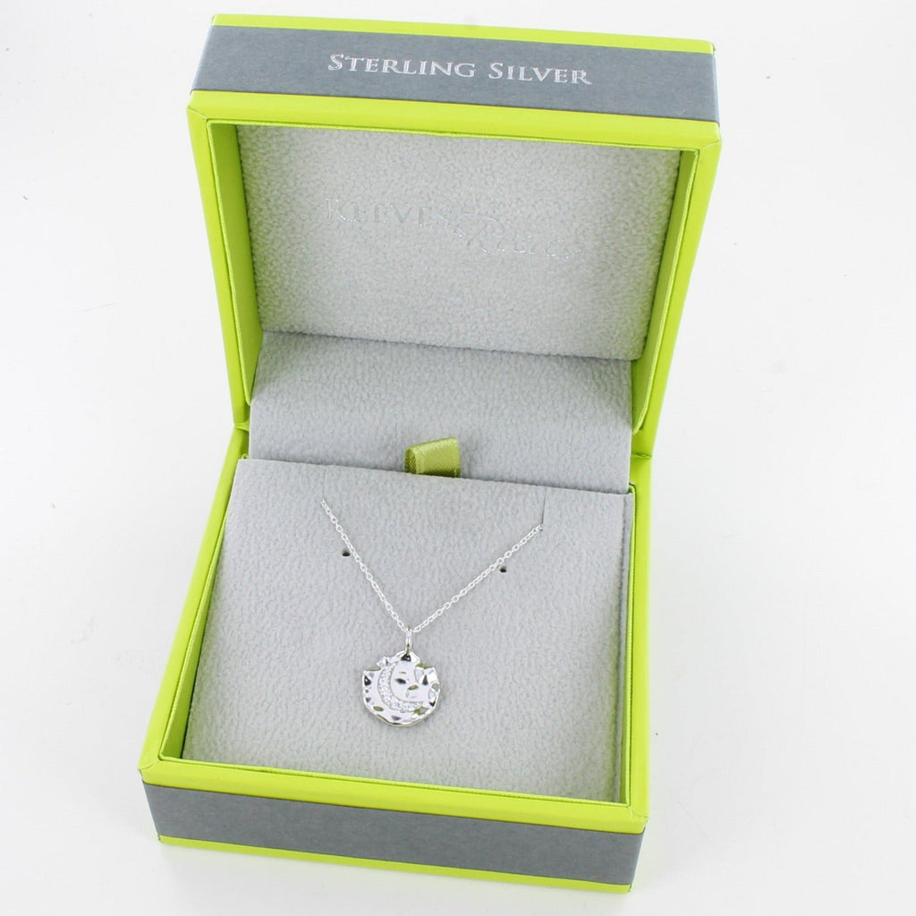 Silver disc necklace with a moon in the centre, filled with cubic zirconia stones. Hangs on an adjustable silver chain and in a Reeves & Reeves grey and green branded box.