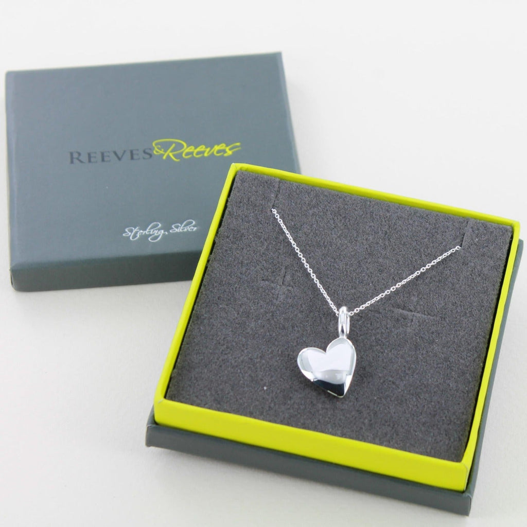 solid silver heart pendant on a silver chain. Shown in a Reeves & Reeves grey and green branded gift box.