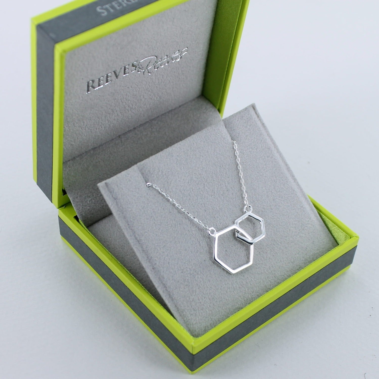 Silver Hexagons Necklace, two interlinking hexagons sat centrally on a silver chain. Shown in a Reeves & Reeves gift box.