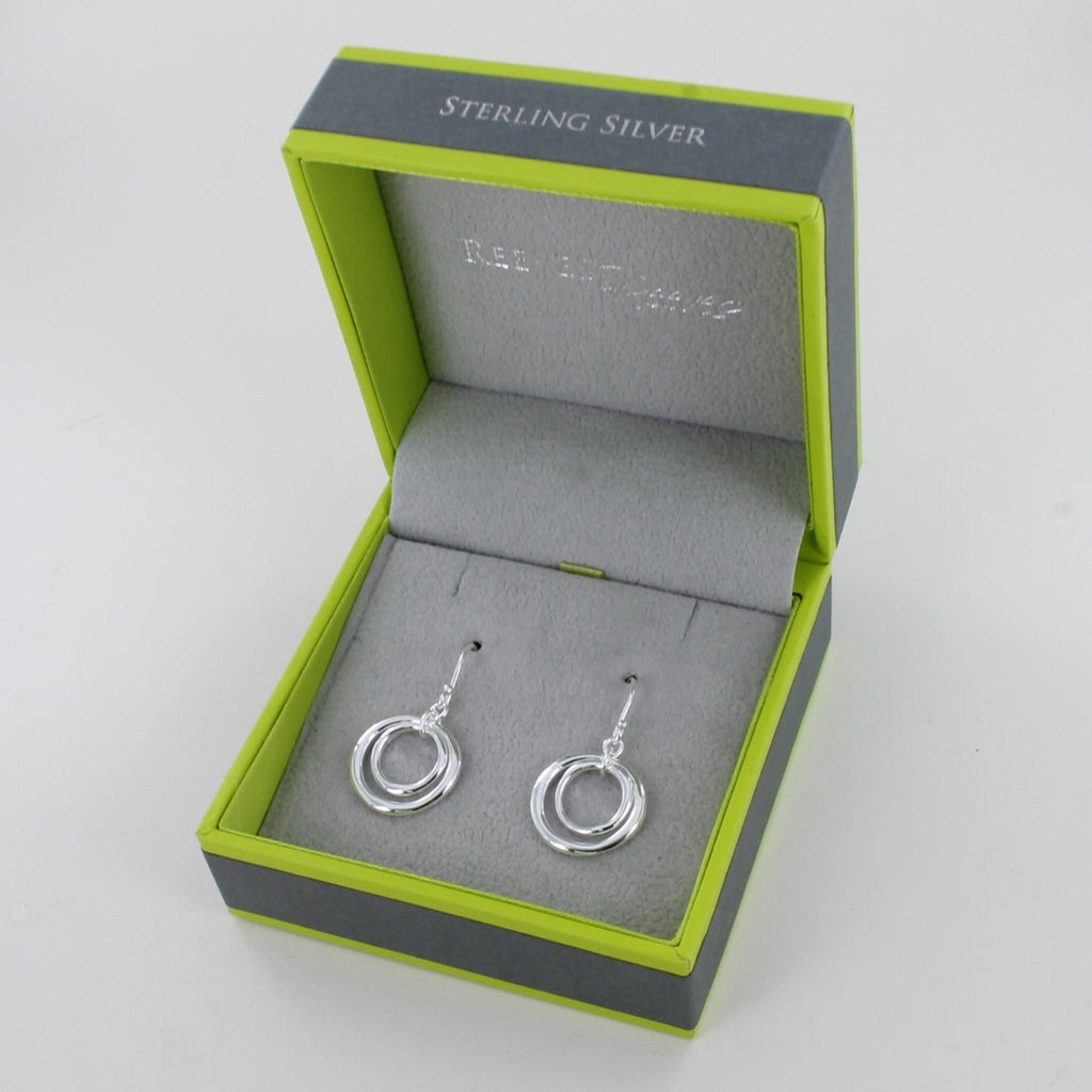 A pair of sterling silver twin ring drop earrings, with two circle silhouettes, the smaller hung inside the larger and on silver hooks. Shown in a Reeves & Reeves gift box.