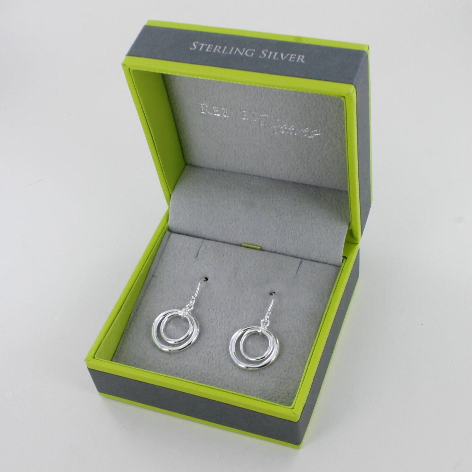 A pair of sterling silver twin ring drop earrings, with two circle silhouettes, the smaller hung inside the larger and on silver hooks. Shown in a Reeves & Reeves gift box.