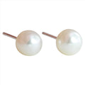 A pair of white freshwater pearl stud earrings.