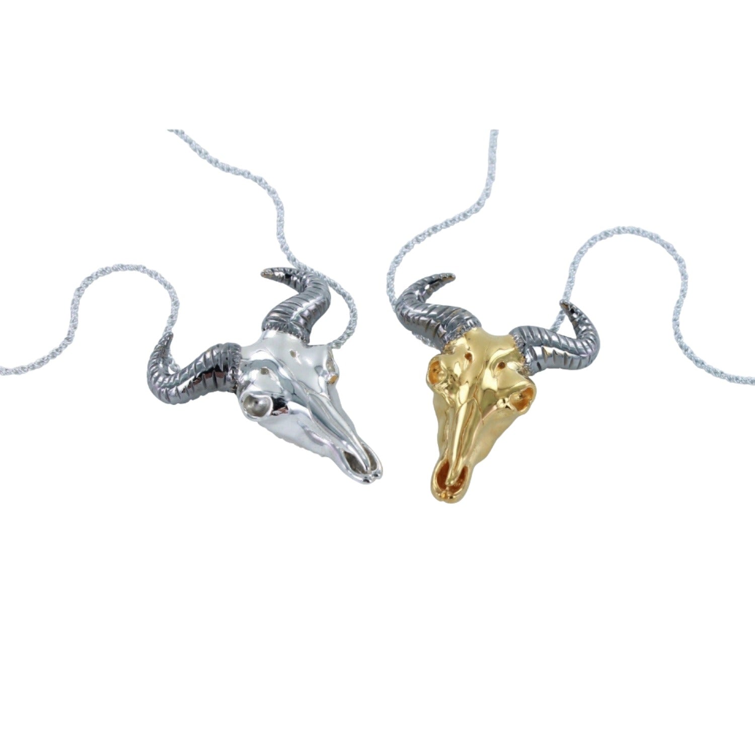 Two sterling silver necklaces, one with 18ct gold plate finish, featuring wildebeest skull designs with black ruthenium horns, suspended on adjustable silver chains.